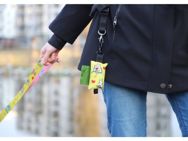 Practical dog poop bag holder attached to a leash, featuring vibrant sublimation printing and a secure carabiner clip.