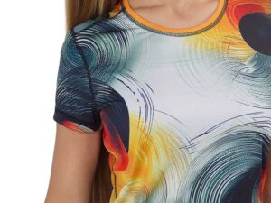 Close-up of the womens sublimated sports t-shirt with a bold, abstract print in shades of orange, red, black, and green. Design your own version with AMGS Group and stand out during your workout!