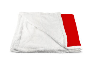 Folded sherpa blanket revealing the soft white plush lining and a section of the red microfiber printed side.